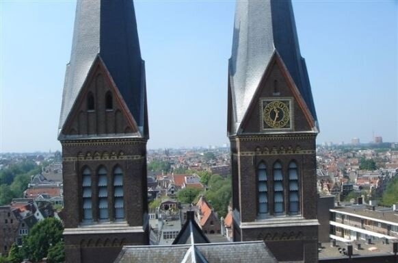 Uitzicht vanaf een dak tussen twee kerktorens over Amsterdam