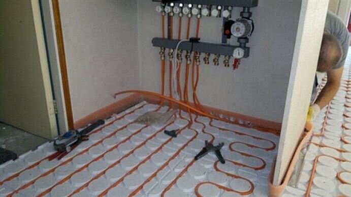 Verdeler en leidingen van vloerverwarming tijdens de aanleg